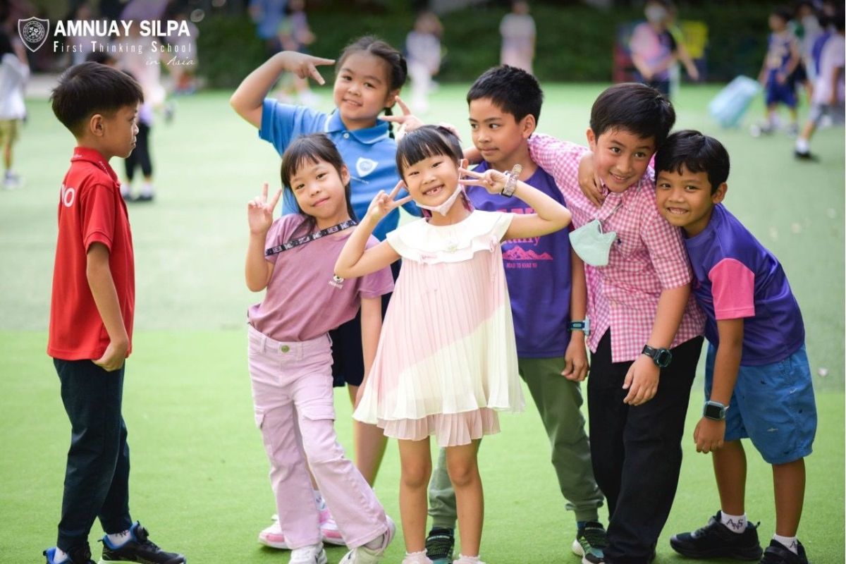 Primary school children playing outdoors at Amnuay Silpa School campus in Bangkok
