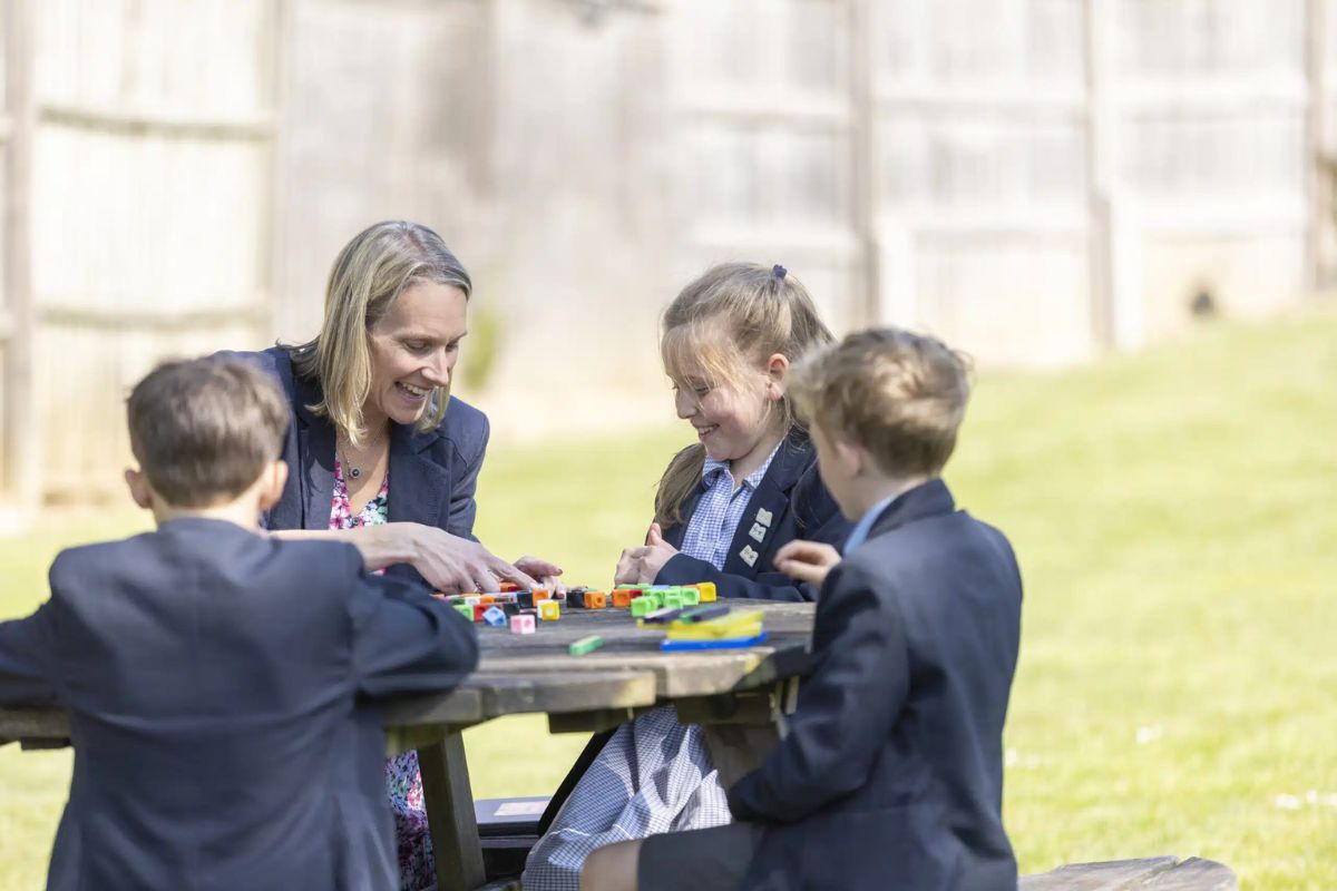 Teachers at Cranleigh School engaging with pupils outdoors, fostering curiosity and a dynamic learning experience.
