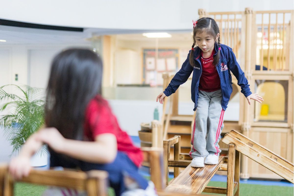Primary school children engaged in play-based learning activities in a colourful classroom