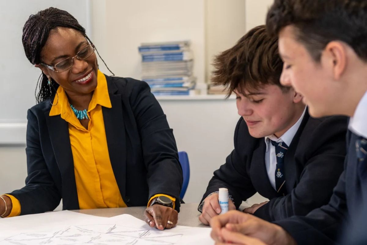 Sixth form students collaborating with teacher in an academic learning environment

Caption options