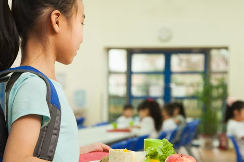 Children enjoying a healthy school meal with vegetables, fruit, wholegrains and protein